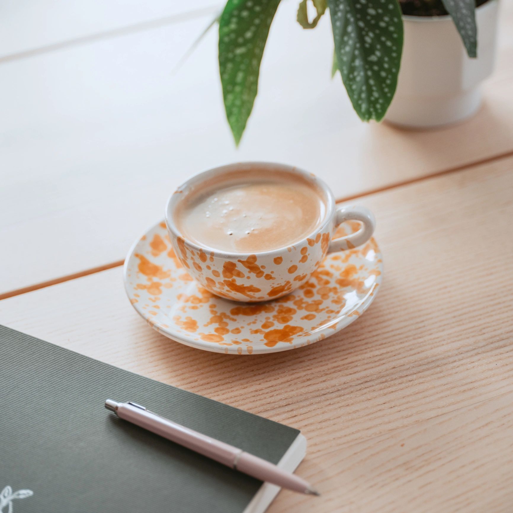 Coffee cup and notebook on a home table